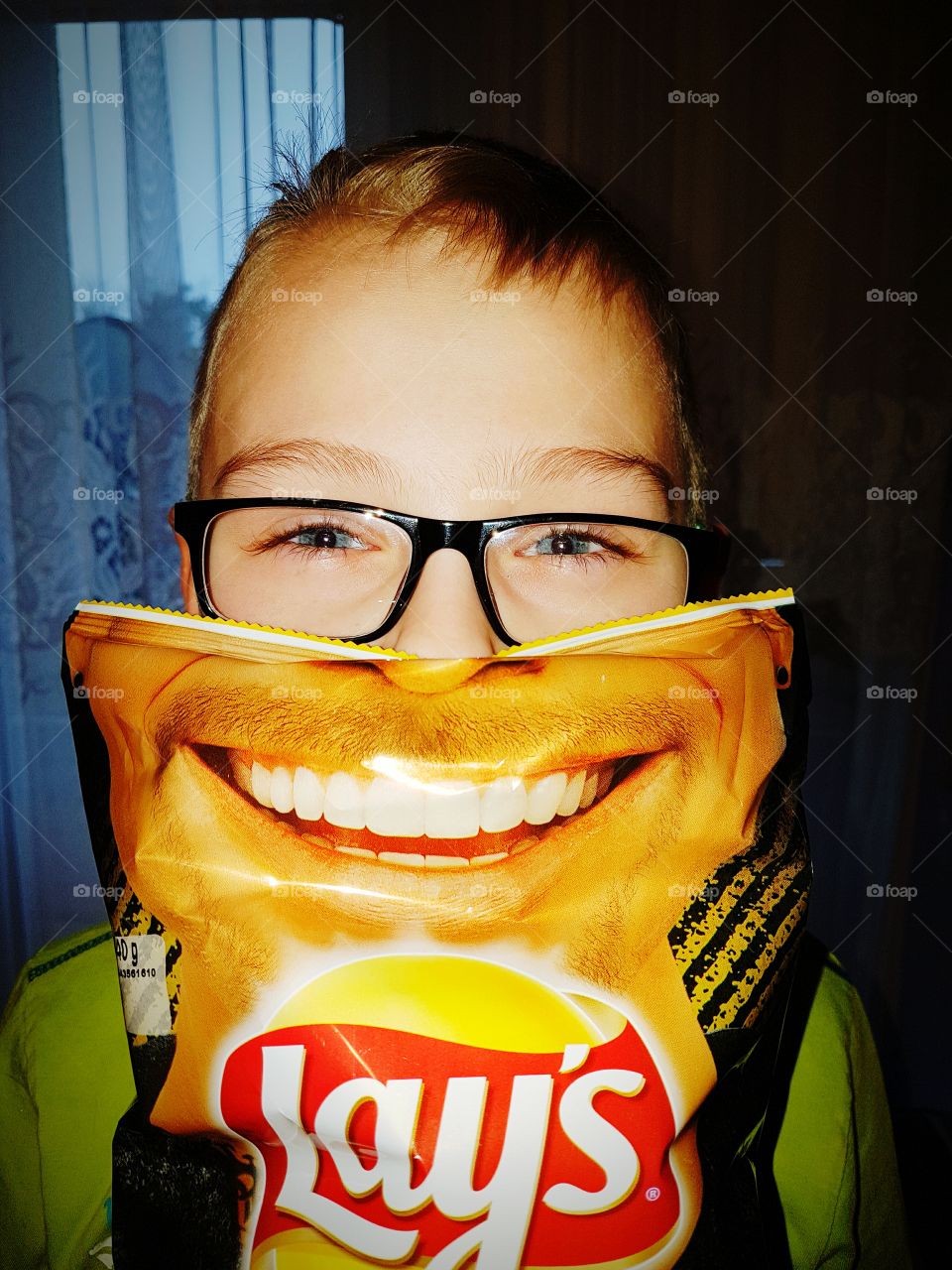 Close-up of a boy with packet of potato chip