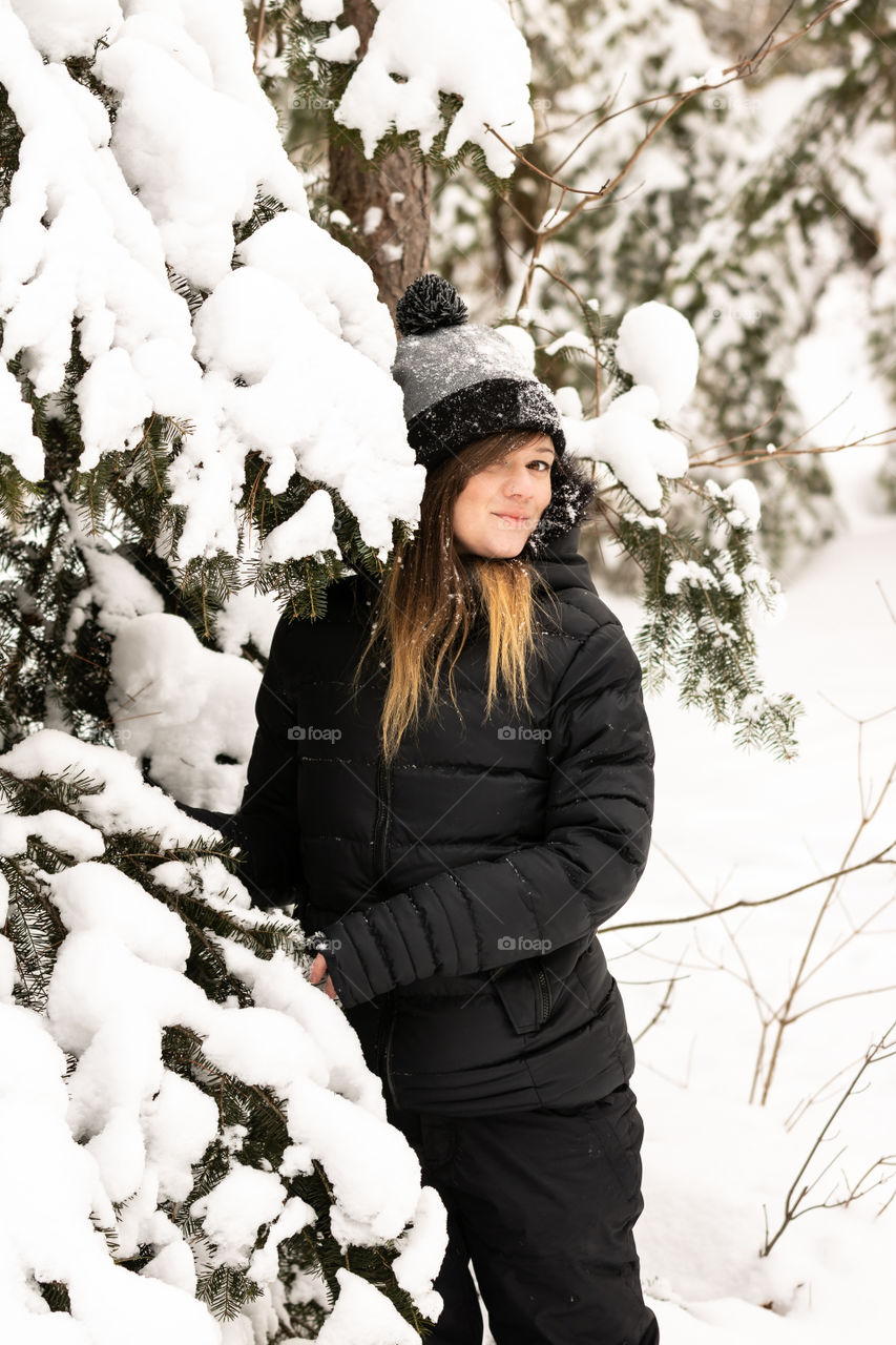 Young attractive female having fun outside in a snow covered winter wonderland scene. 
