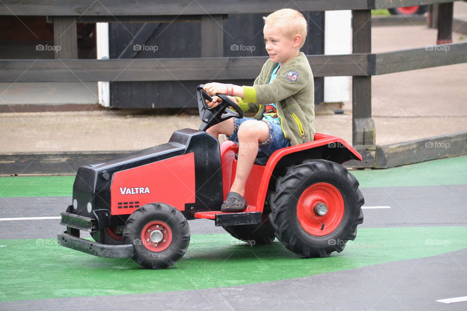 Boy driving a toy tractor