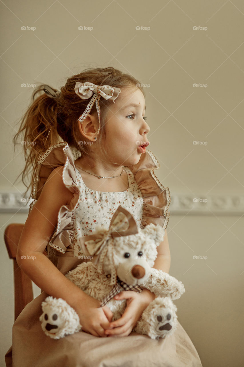 Vintage portrait of a beautiful little girl with teddy bear 