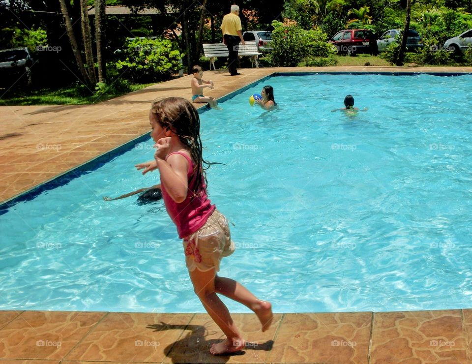 Girl running on the edge of the pool