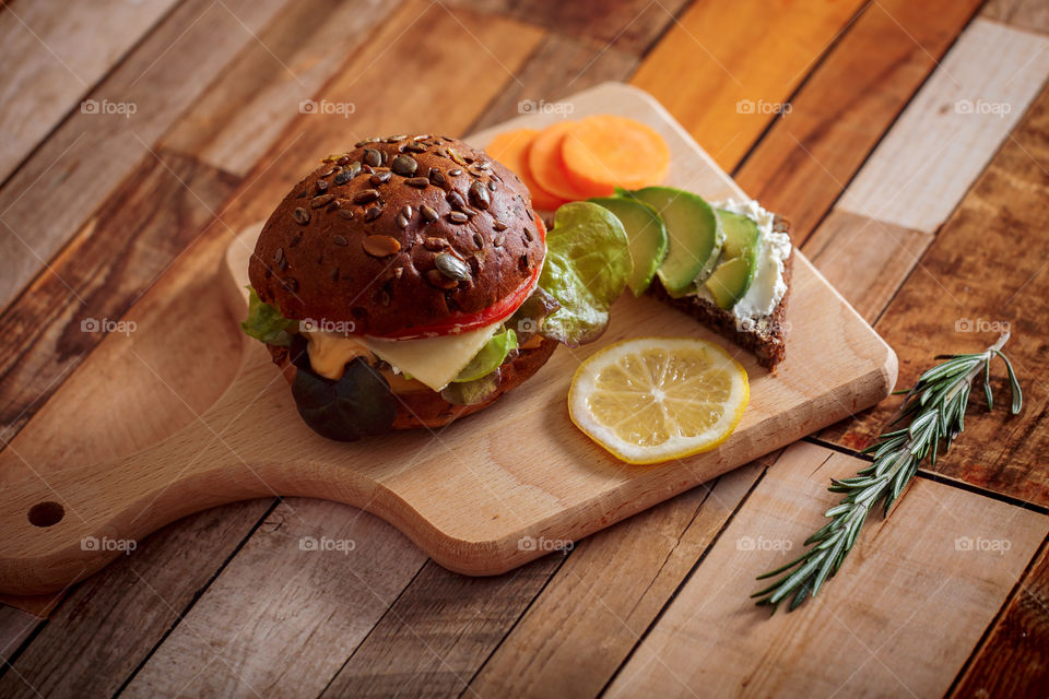 Dark burger with grain bread, cream cheese and avocado