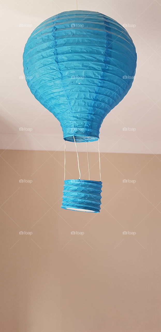 A small, blue hot air balloon. The perfect shot for a simple children's topic, or even a day out. With a warm hue, this image can fit anywhere.