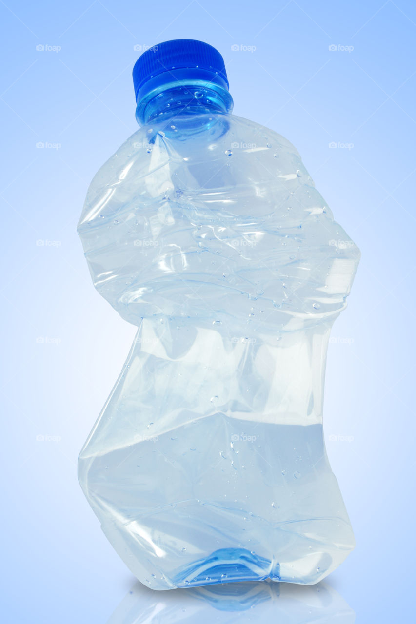 Crushed water bottle on blue background