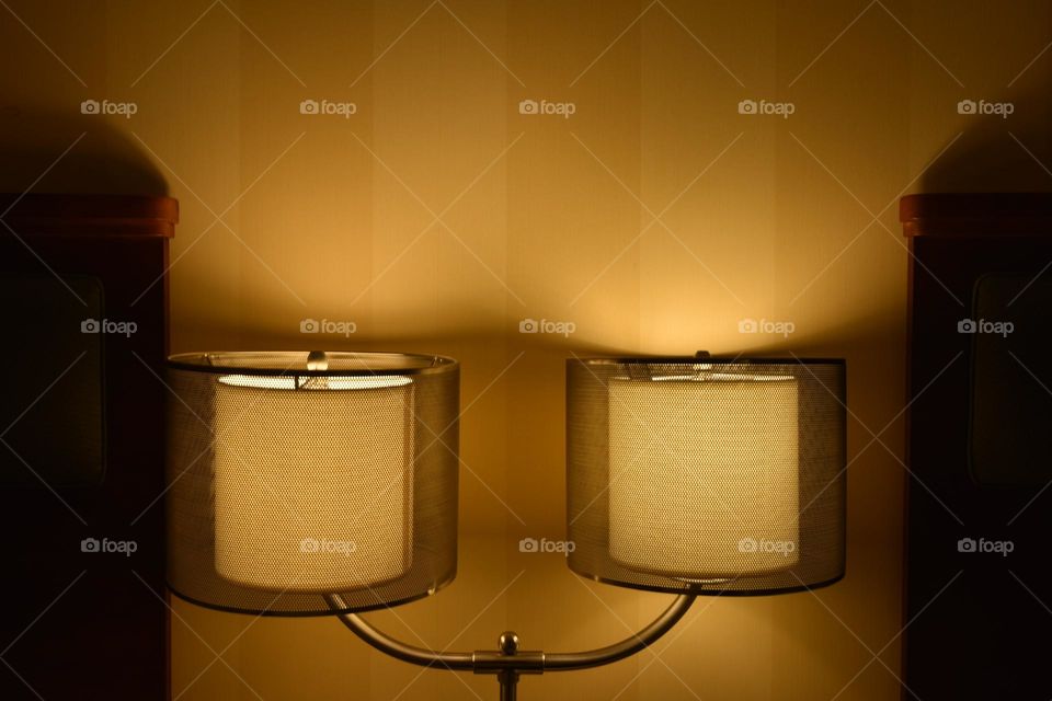 Night lamps casting a yellowish hue on the wall.