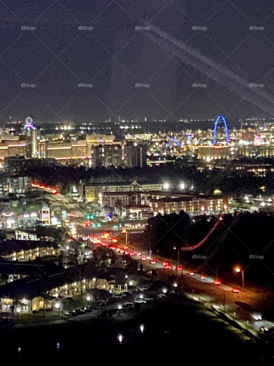 A nighttime view of city lights and a highway taken from above