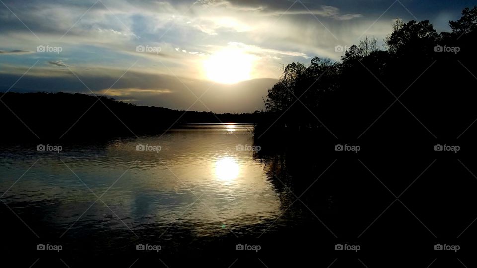 sun reflecting on lake during sunset.