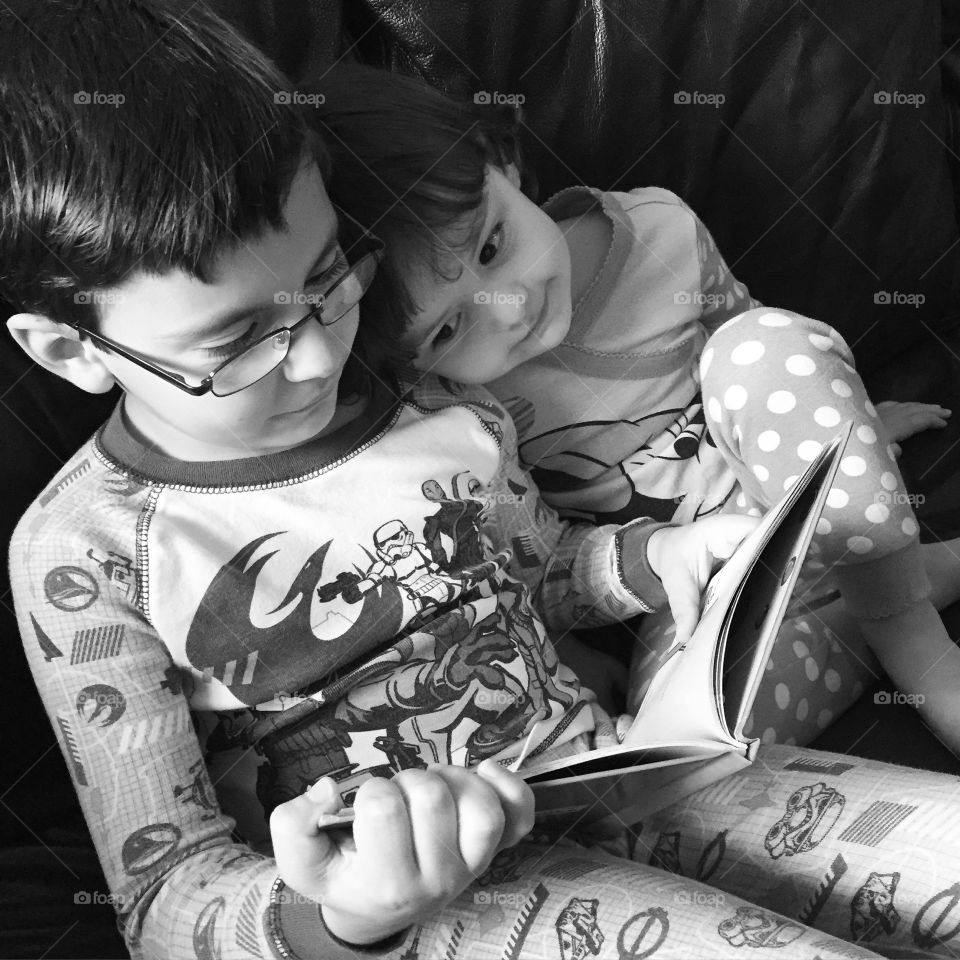 Brother and sister reading story book