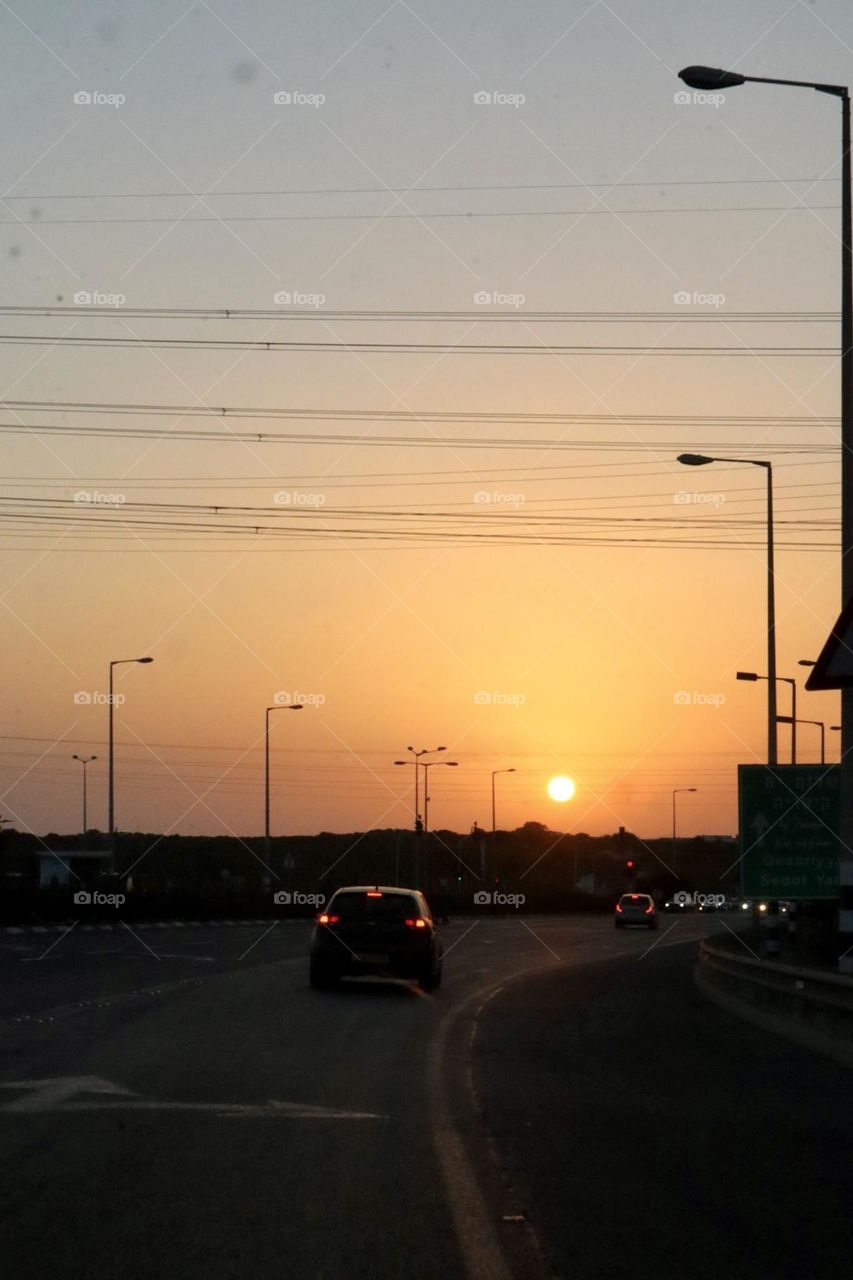 Cars drives on the road during sunset 