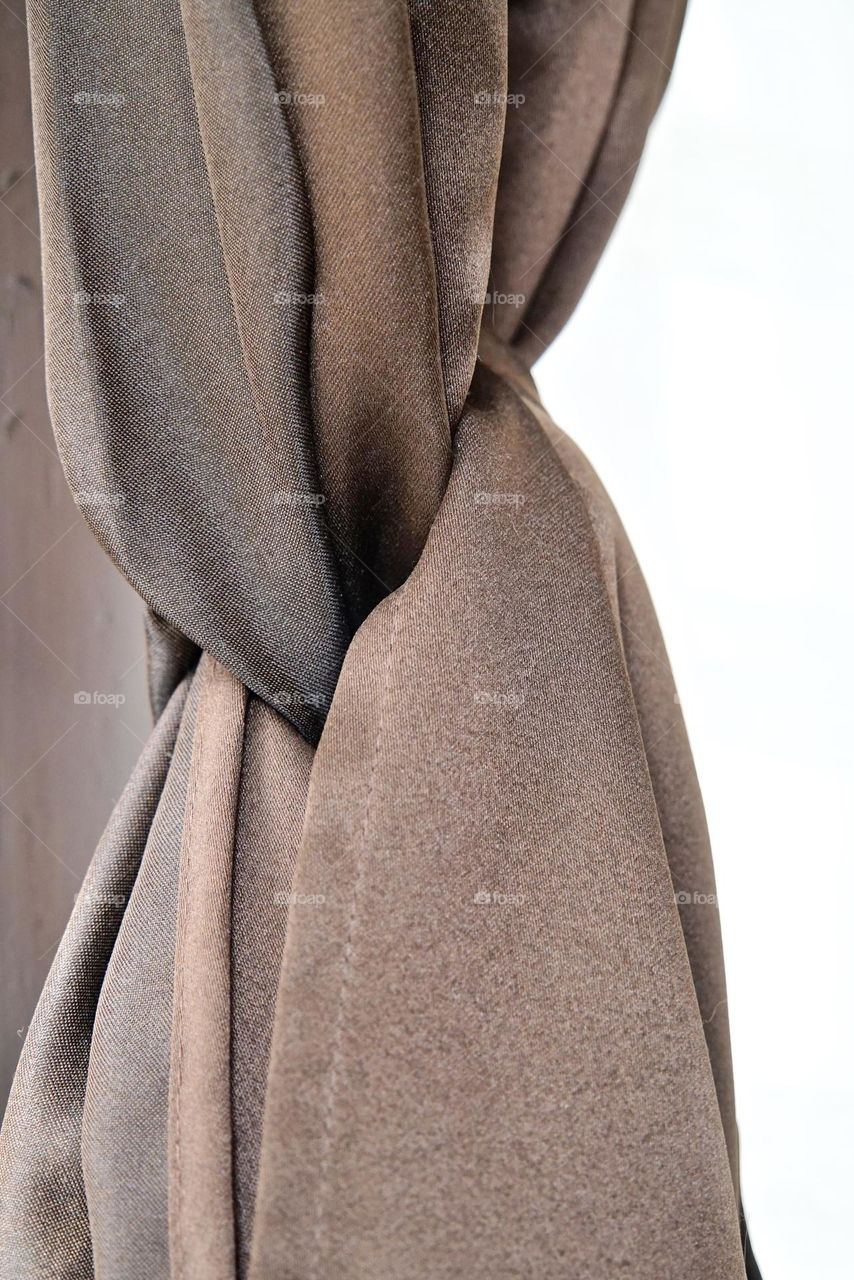 The perfect knot in a shiny chocolate curtain