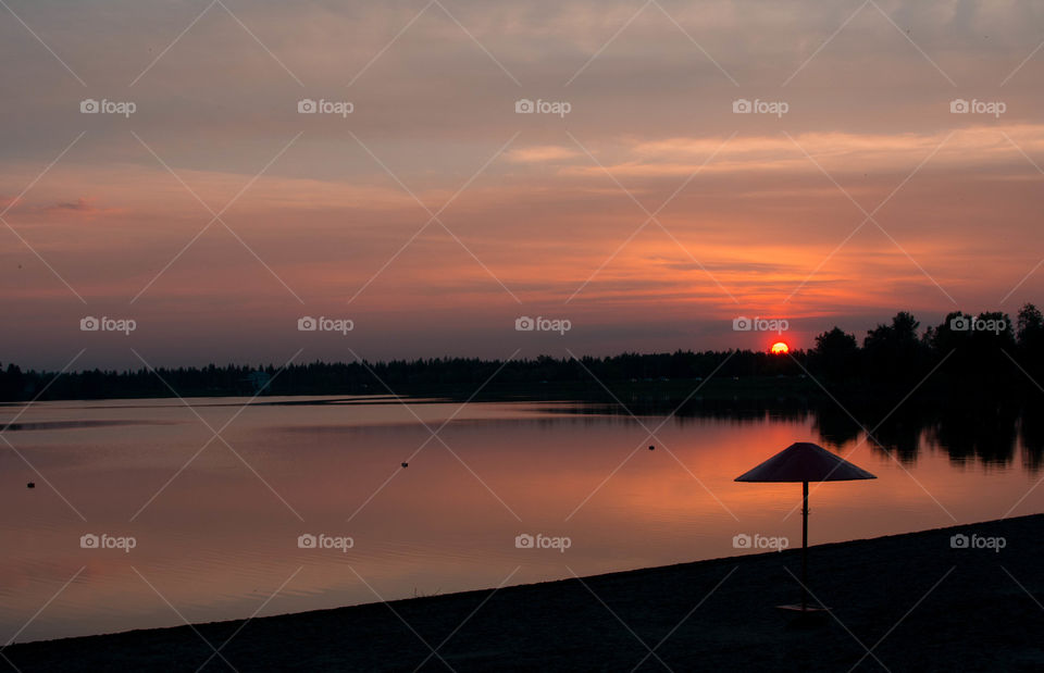 Summer sunset and umbrella silhouette