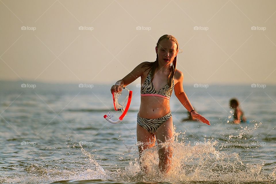 Running girl. Girl running in the water at the beach