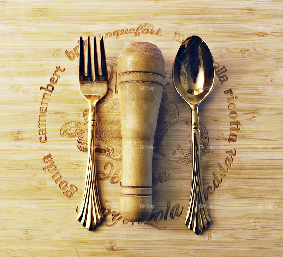metal and wooden utensils laying on a wooden cutting board