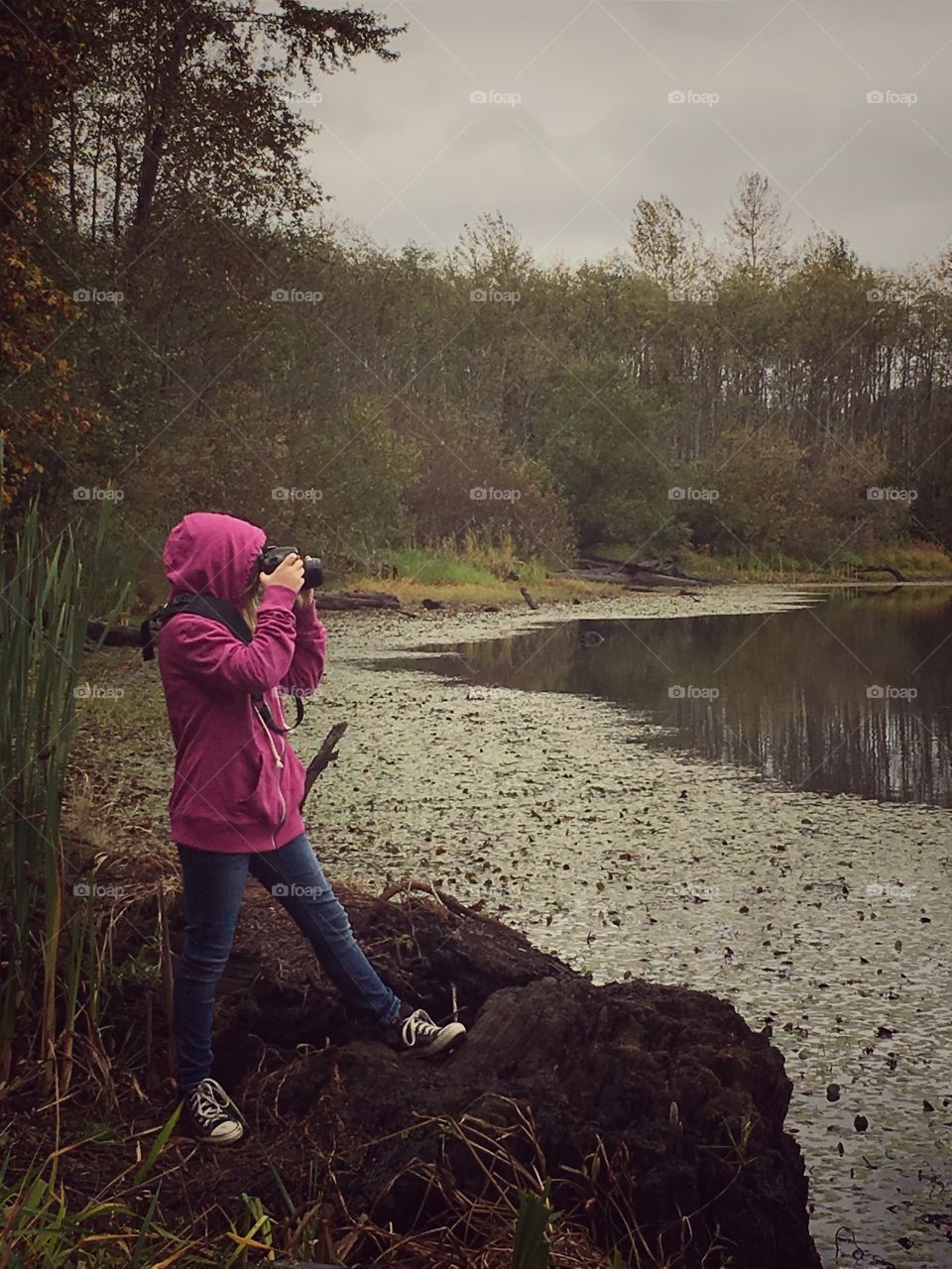Young photographer in pink hoodie.