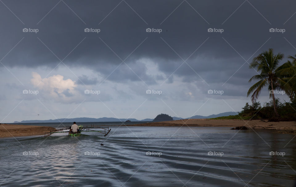 A Indonesian fisherman going back home on his boat before the storm