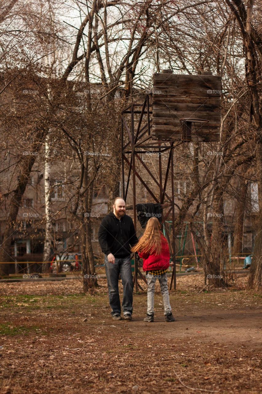 Father and daughter playing basketball in the yard