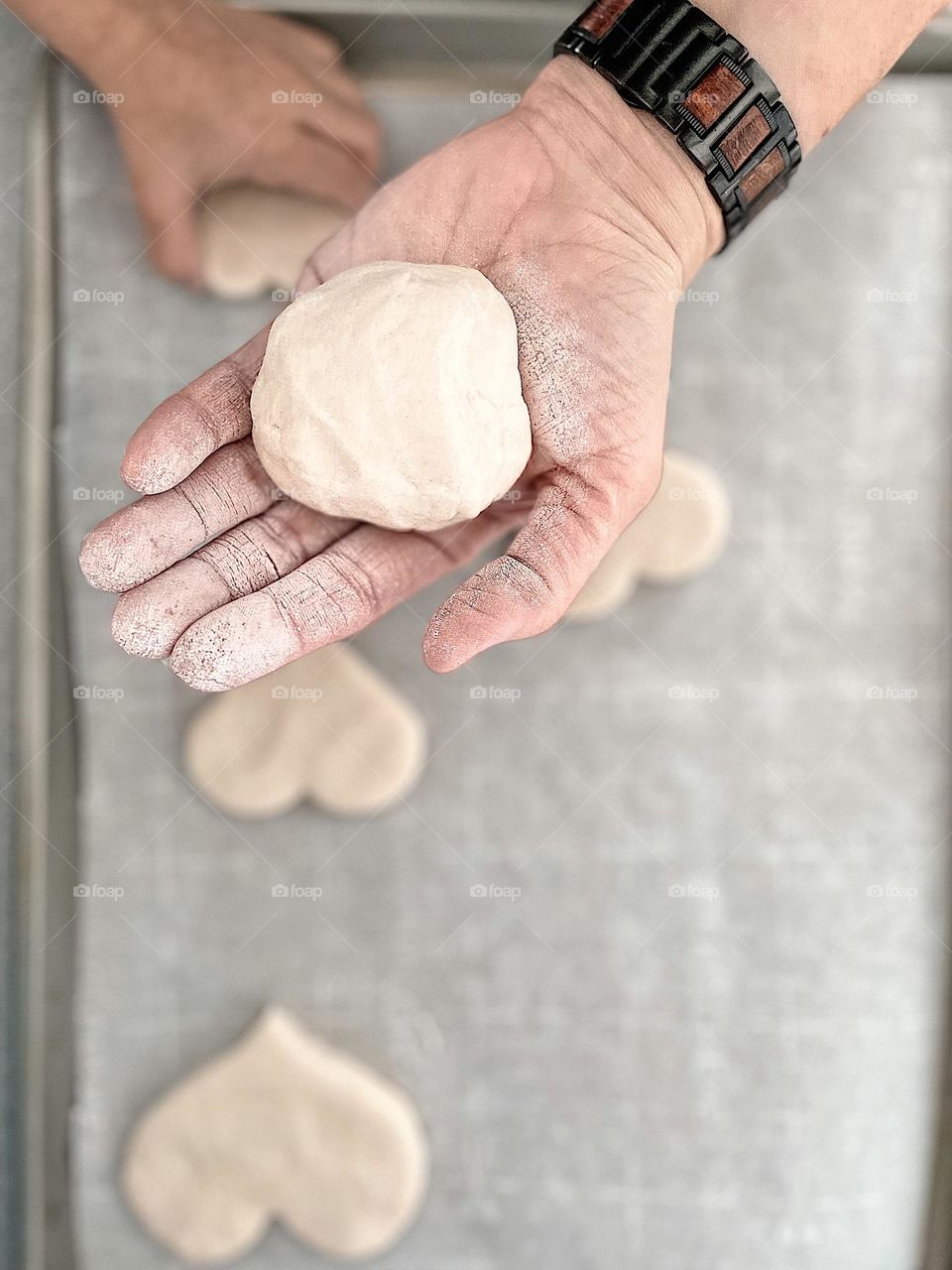 White flour covered hands in the kitchen, heart cookie thief, white ball of dough, white heart shaped cookies, white dough in the kitchen, baking with flour in the kitchen, toddlers hands being sneaky