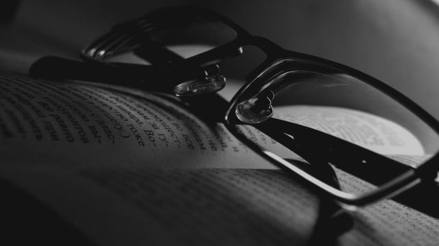 black and white photo.. glasses on the book