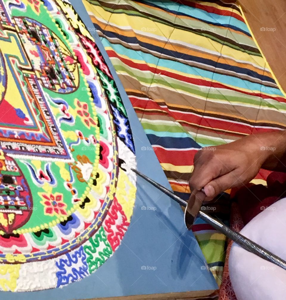 Closeup of a Buddhist monk creating a sand mandala