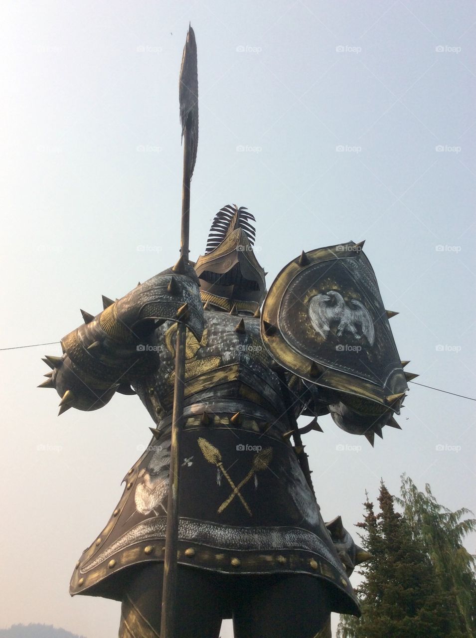 A large outdoor ornate statue of a knight, heroically posed with his axe and shield.