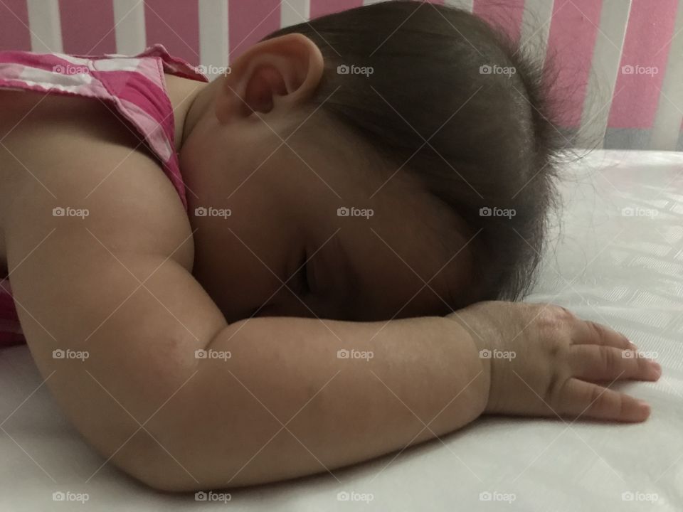 Sleeping baby girl sideview in crib
