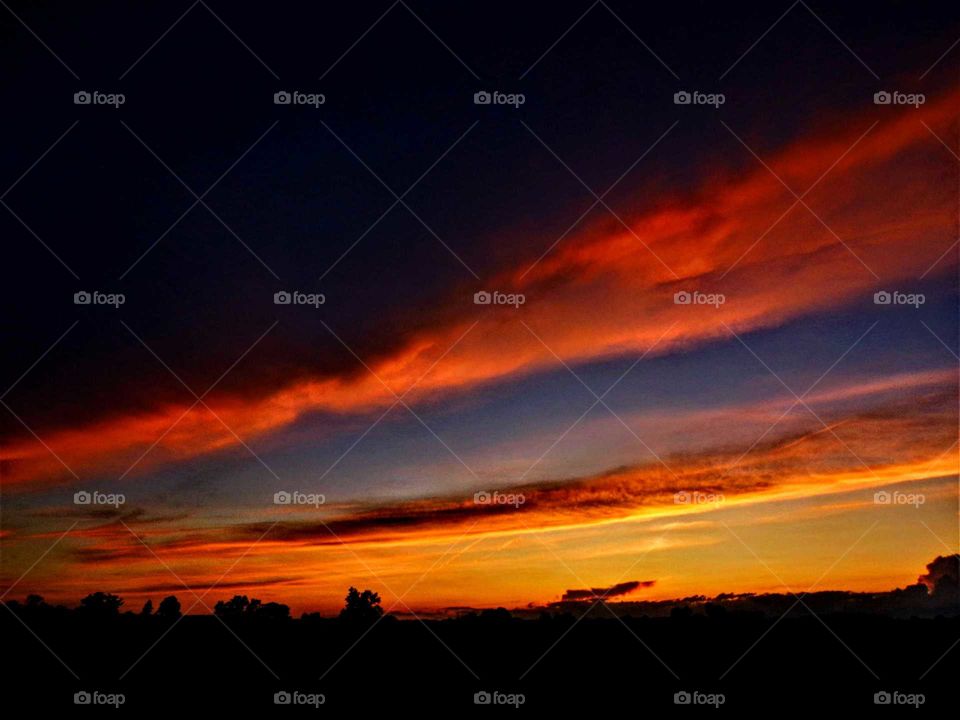 Band of lava filled clouds pouring across the cool sky.