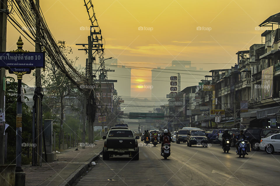 The early morning sunlight shining on buildings and the cars on the road at Bangyai City of Nonthaburi in Thailand.  January 14, 2019