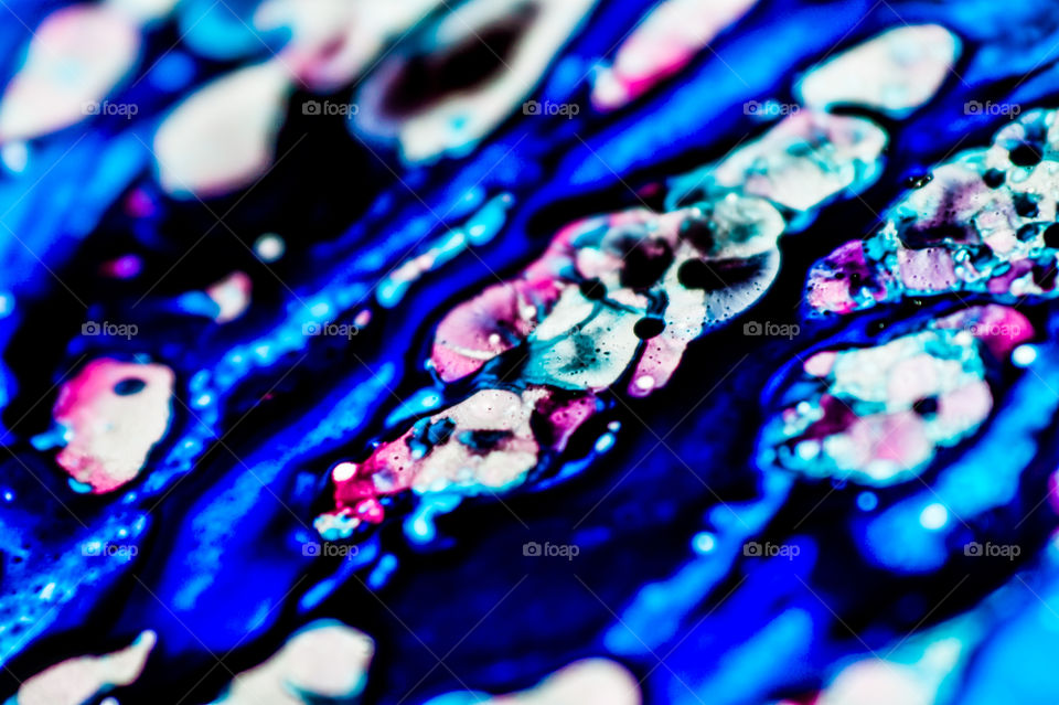 The ink to refill the printer cartridge was spilled onto the white washbasin and the paints blended into abstract drips and patterns.
