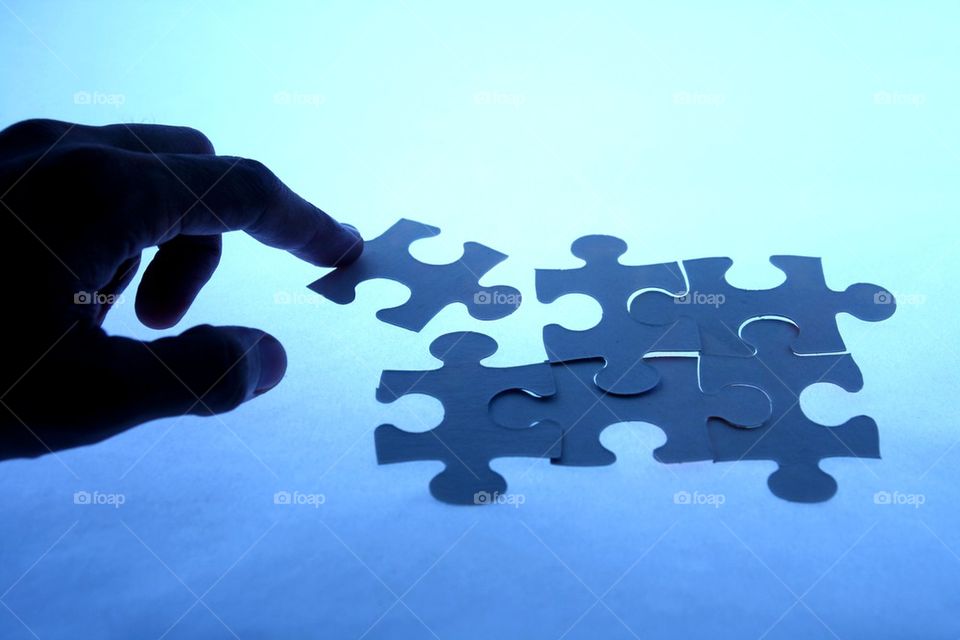 hand touching a loose piece of a puzzle