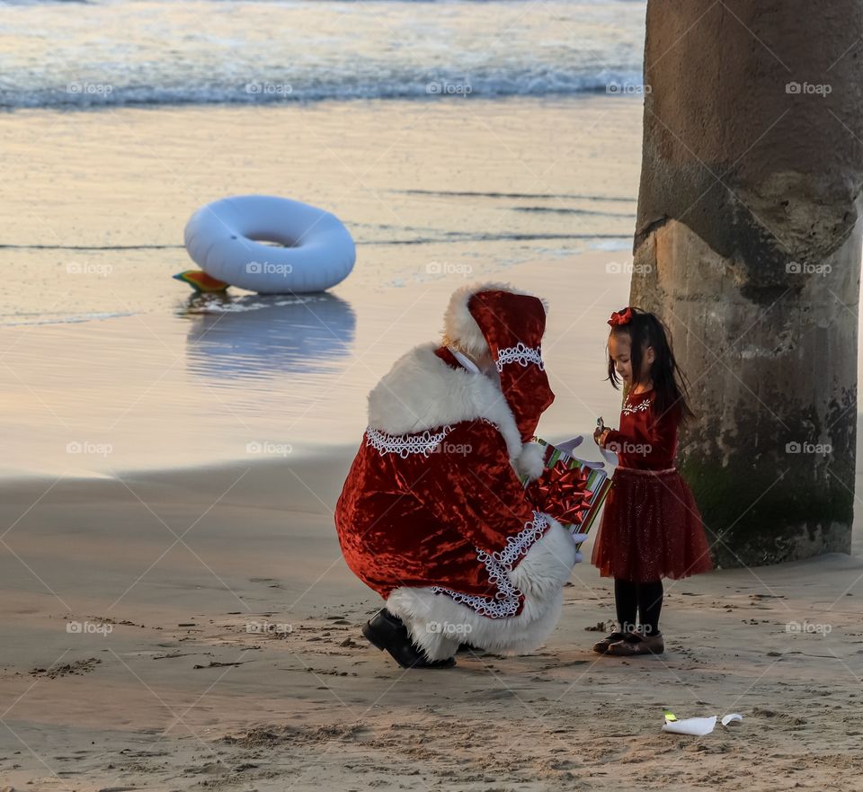 Little girl opening a present with Santa