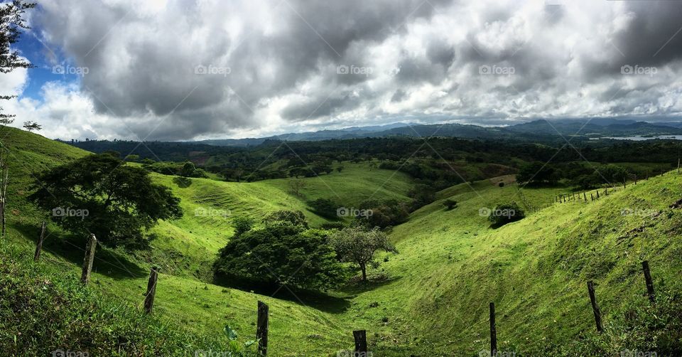 Green valley under a cloudy sky.