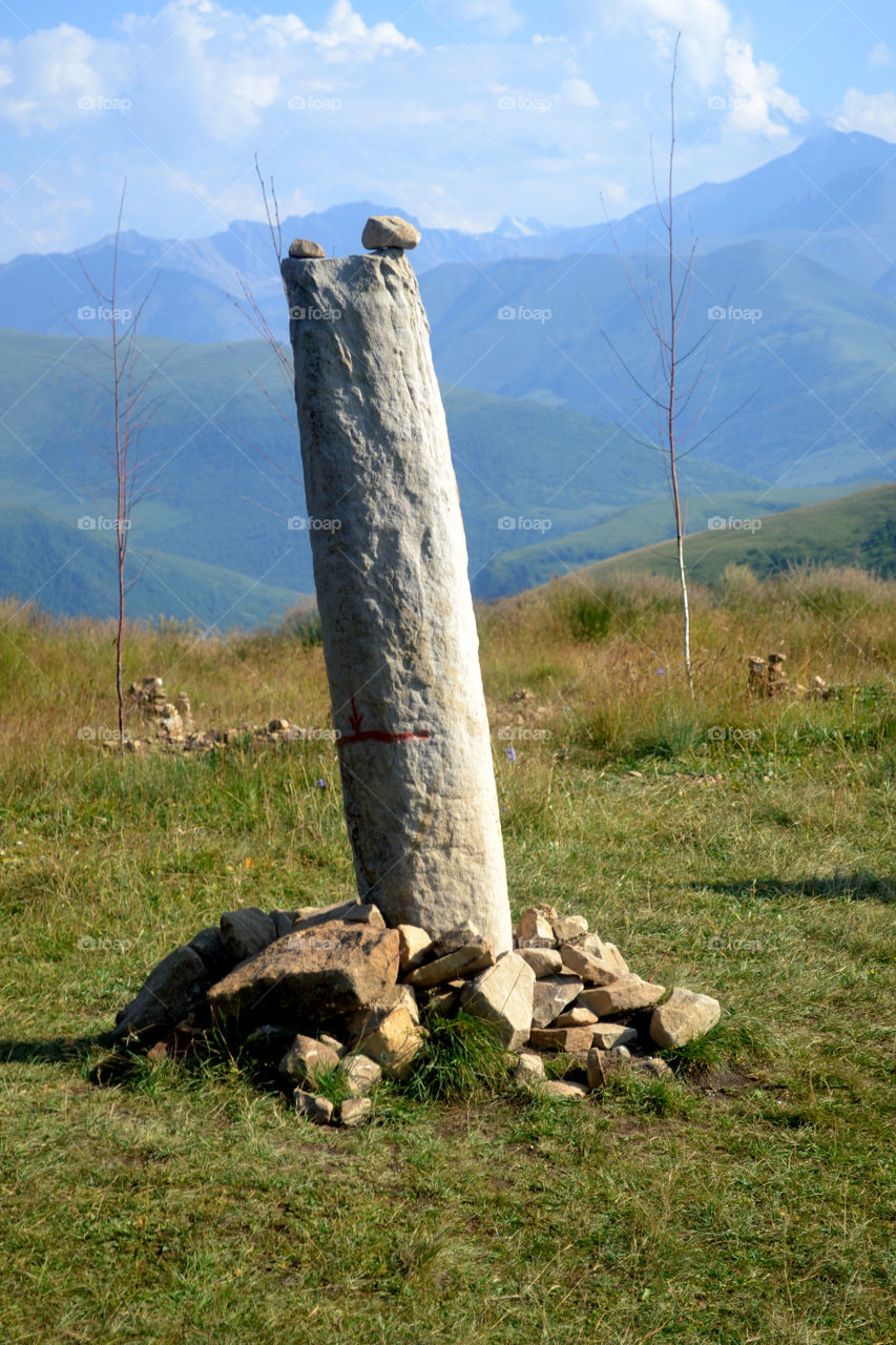 Big menhir in the mountains of the North Caucasus on a cloudy summer day. Caucasus, Russia