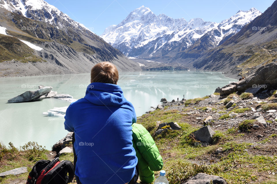 Man enjoying view on a glacier lake after tiring hiking