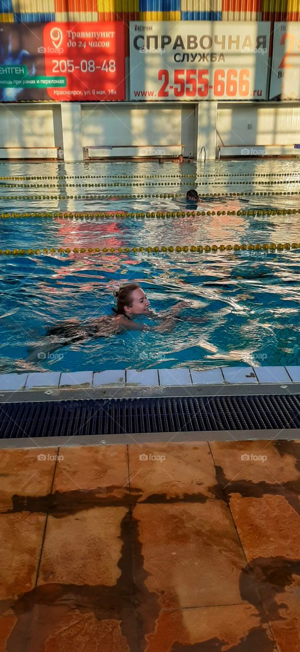 девушка плывет в бассейне