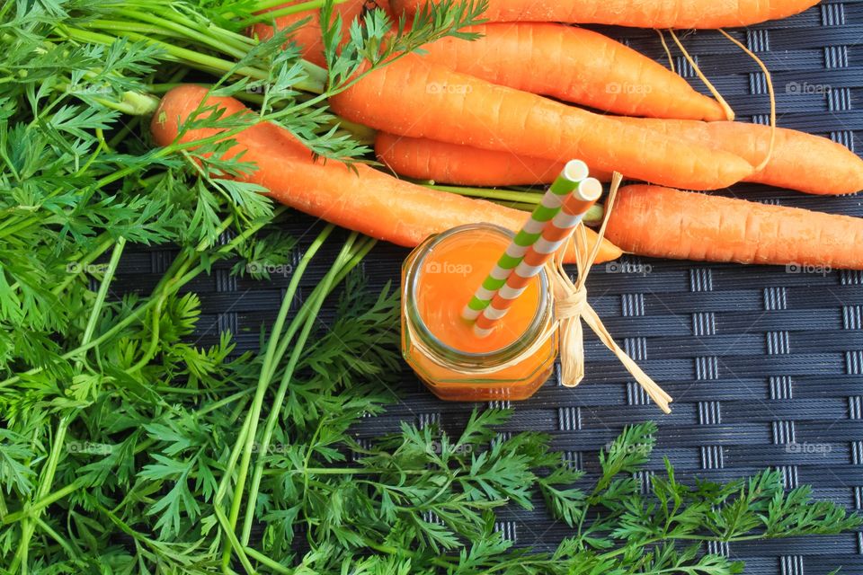 Fresh carrot juice next to home grown carrots