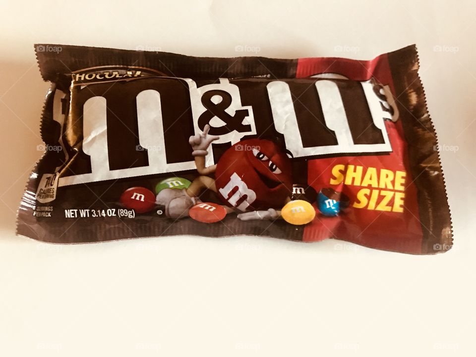 Delicious chocolate bite size chocolate m&m candies on display against a white background. 