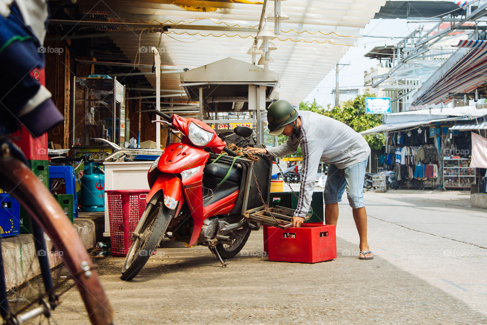 Vietnamese man prepares beer crates for transportation