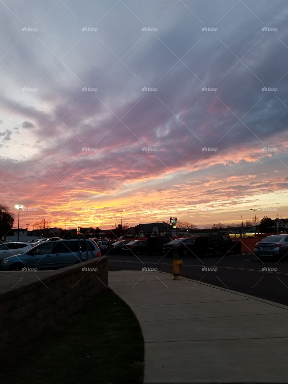 A bright, vibrant sunset over a thrift store parking lot.