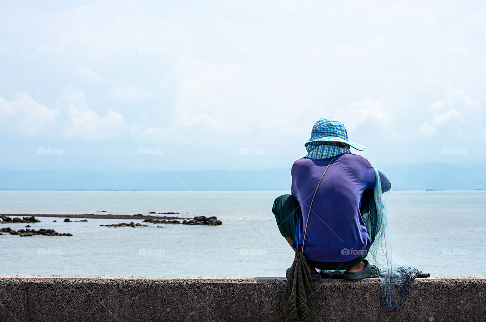 Man holding fishing nets  Background sea and sky.