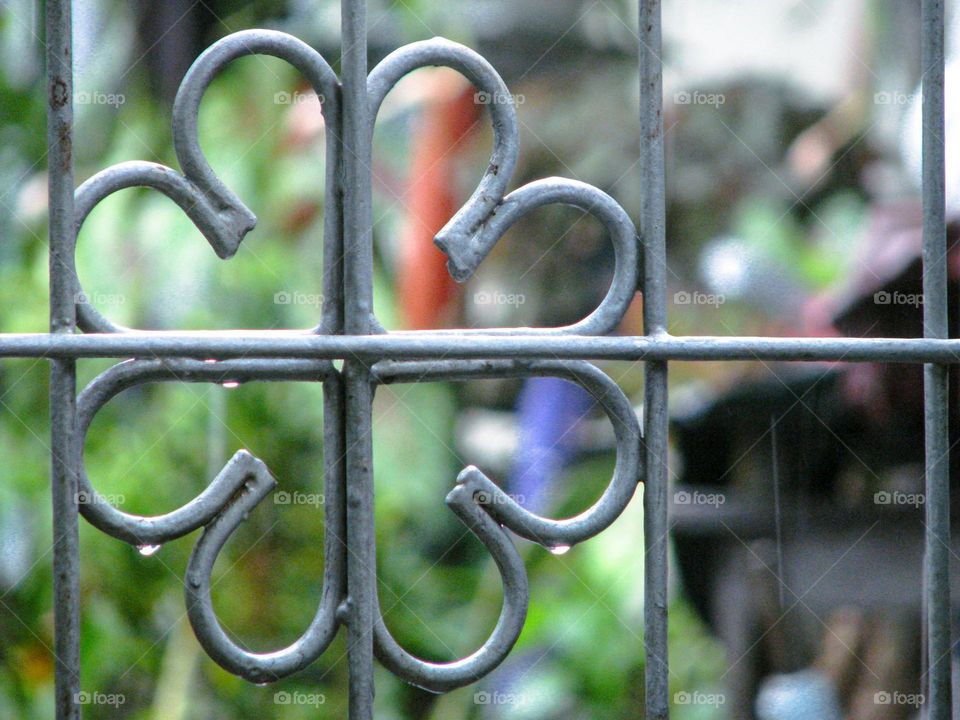 Close-up view of part of an iron fence with a heart-shaped ornamental design