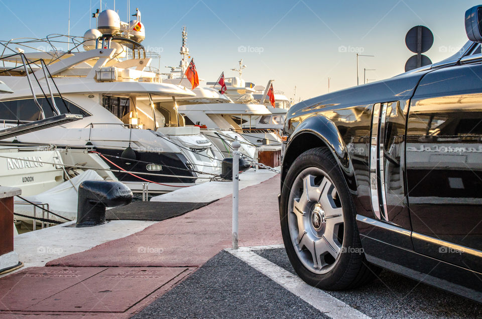 Rolls-Royce parked next to Yachts . Black Rolls-Royce parked at Puerto Banus, Spain