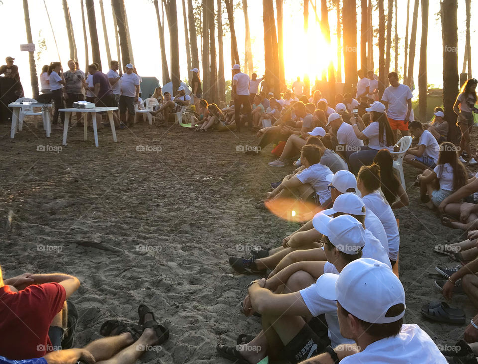 Community of peoples in the forest. Sunset 