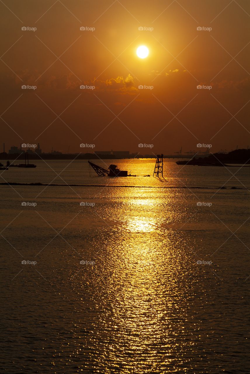 A beautiful golden sunset descends upon the Savannah river of Georgia seen from a riverboat cruise.