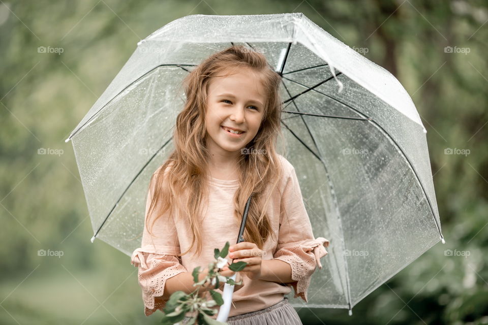 Girl in blossom garden at rainy day