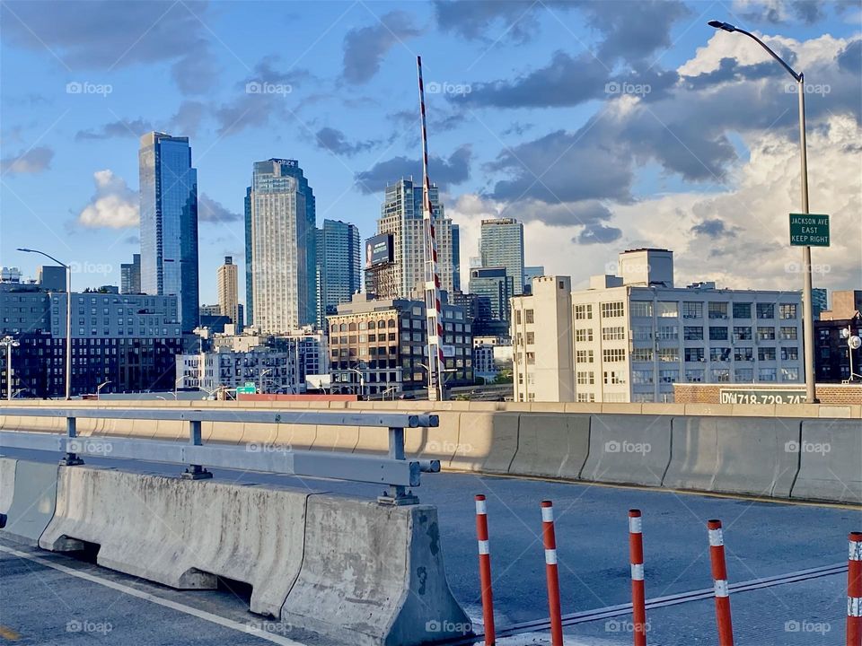 The skyscrapers of “Long Island City”, Queens can be seen from the “Pulaski Bridge” in the warm light of the setting sun during the golden hour. 2023. Hypnotic Productions