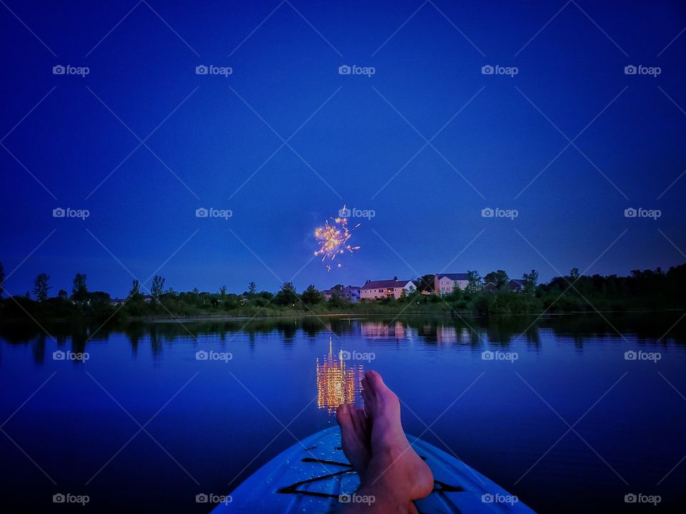 Watching fireworks from a paddle board on a lake