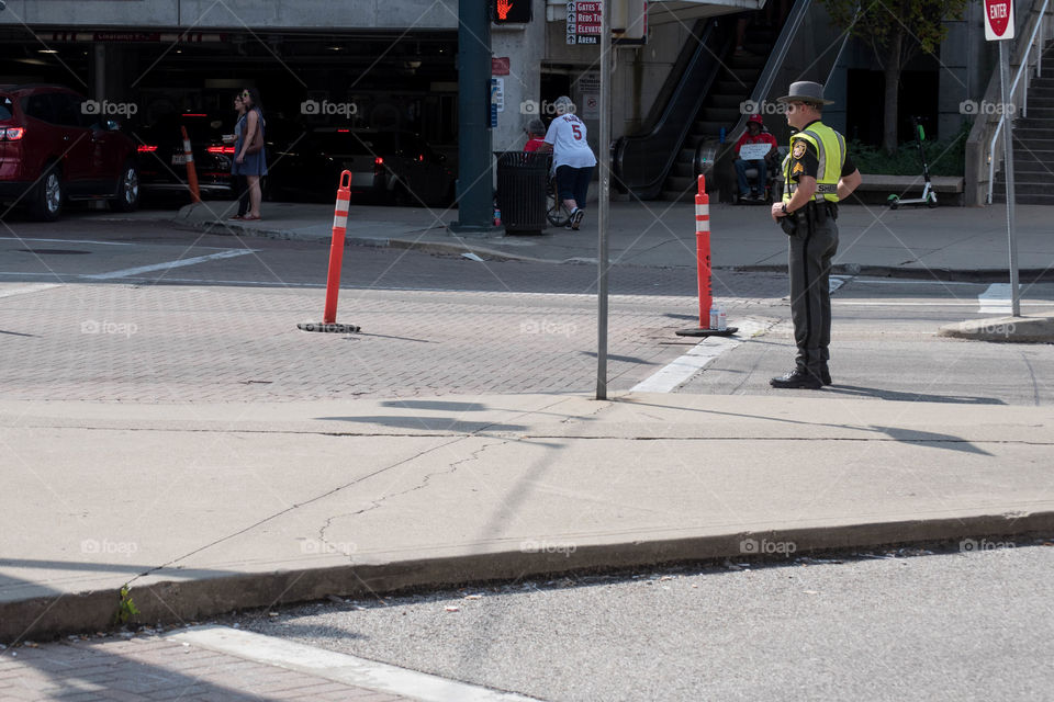 Police officer standing in an urban street directing traffic