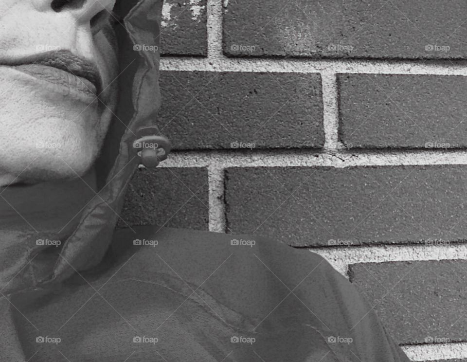 A pattern of bricks behind a woman’s profile.