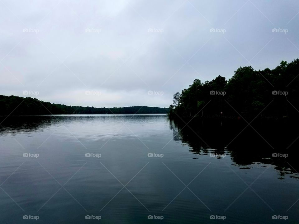 rain is coming.  rain laden clouds over the tranquil lake.