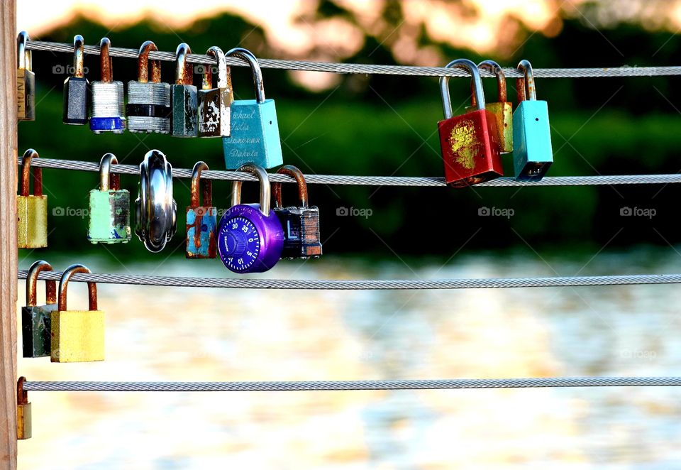 Metal love padlocks hanging on the fence